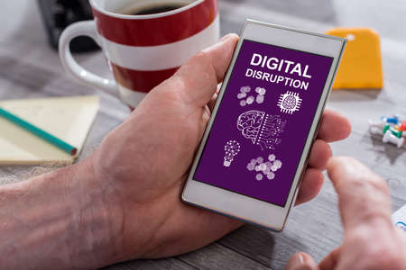 Male hand holding a smartphone with digital disruption conceptの写真素材
