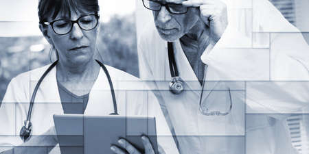 Two mature doctors discussing about medical report on tablet, geometric patternの写真素材