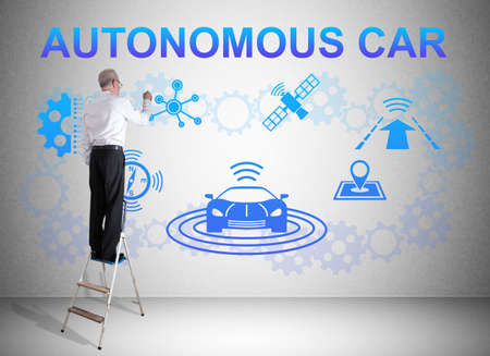 Man on a ladder drawing autonomous car concept on a wallの写真素材