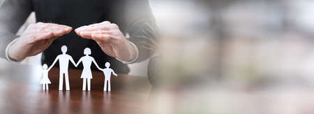 Insurer protecting a family, concept of insured family; panoramic bannerの写真素材