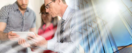 Business people in meeting working on tablet in office; multiple exposure