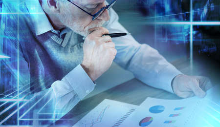 Businessman analyzing marketing charts at office; light effect