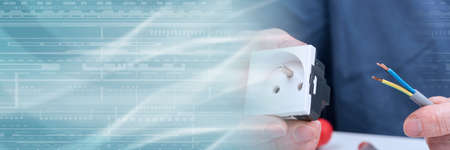 Hand holding an electrical outlet and a power cable; panoramic banner