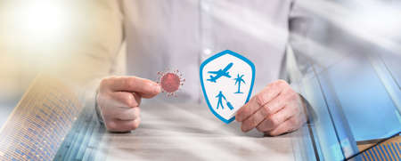 Man holding a virus and shield with travel symbols; concept of prevention and virus protection when...