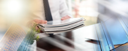 Hands of businessman holding magazines; multiple exposureの写真素材