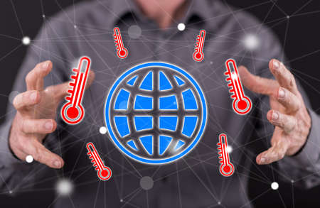 Global warming concept between hands of a man in background