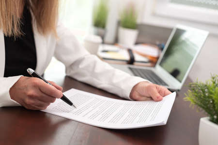 Businesswoman reading and checking document in office (Lorem ipsum text used)の写真素材