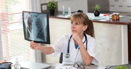 Female doctor looking at x-ray in medical office