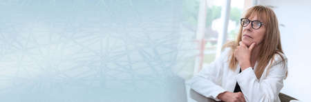 Portrait of thoughtful mature businesswoman at office; panoramic banner