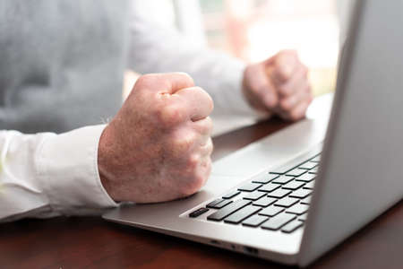 Angry businessman hitting his desk with his clenched fistsの写真素材