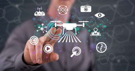 Man touching a concept drone on a touch screen with his fingerの写真素材