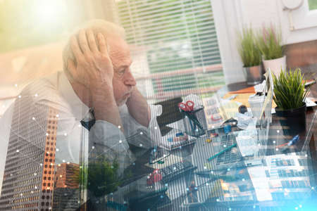 Overworked senior businessman sitting at a messy desk; multiple exposure