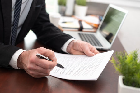 Businessman reading and checking document in office (Lorem ipsum text used)の写真素材