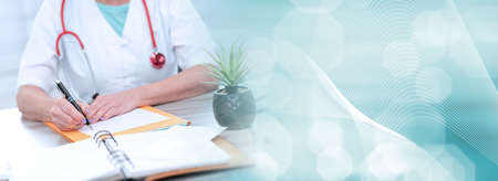 Female doctor writing a medical prescription in office; panoramic bannerの写真素材