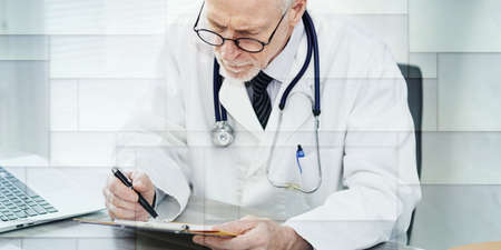 Senior doctor reading a clinical record in medical office, geometric patternの写真素材