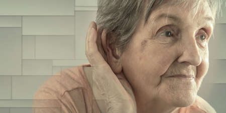 Elderly woman having earing problem, geometric patternの写真素材