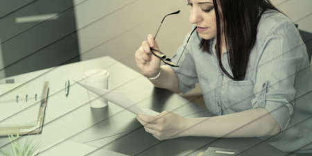 Businesswoman checking document in office, geometric patternの写真素材