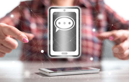 Smartphone with message concept between hands of a woman in background