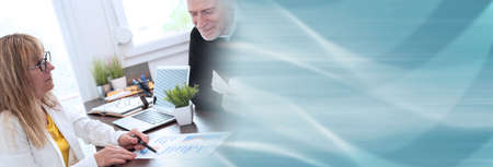 Two mature business people working together in office; panoramic bannerの写真素材