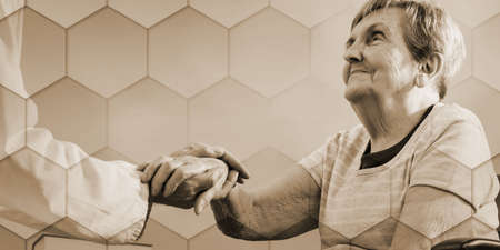 Doctor holding the hand of an elderly woman, geometric patternの写真素材