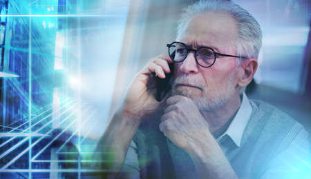 Portrait of senior businessman talking on mobile phone; light effect; multiple exposureの写真素材