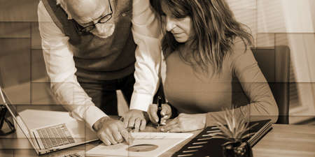 Coworkers working on financial statistics in office, geometric patternの写真素材