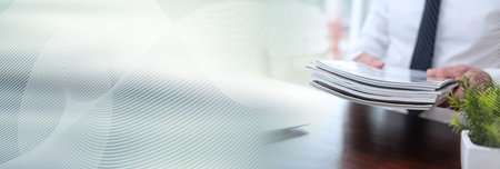 Hands of businessman holding magazines; panoramic bannerの写真素材