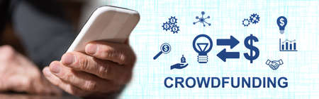 Hand holding mobile phone with crowdfunding concept on backgroundの写真素材