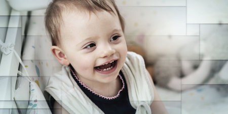 Portrait of smiling baby girl sitting in her bed after sleeping, geometric patternの写真素材