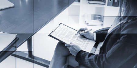 Business woman taking notes on a clipboard, geometric patternの写真素材
