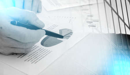 Businessman checking financial charts, at the office; multiple exposure