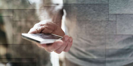 Man standing using his smartphone, geometric pattern