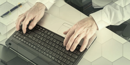Top view of businessman typing on laptop keyboard, geometric patternの写真素材