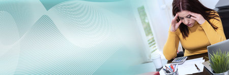 Desperate young businesswoman with hand on forehead sitting at desk; panoramic banner