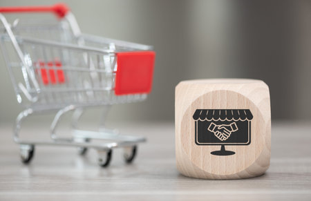 Wooden block with symbol of customer loyalty concept and trolley on backgroundの写真素材
