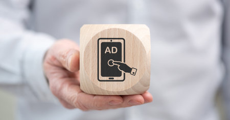 Hand holding a wooden cube with symbol of advertising conceptの写真素材