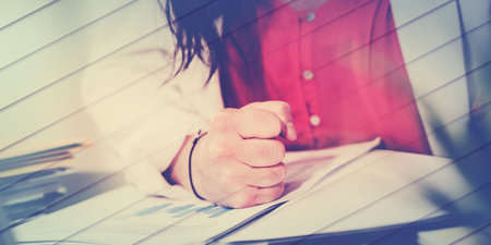 Angry businesswoman hitting her desk with her clenched fist, geometric pattern