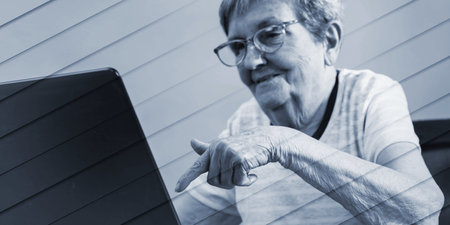 Senior woman using a laptop, geometric patternの写真素材