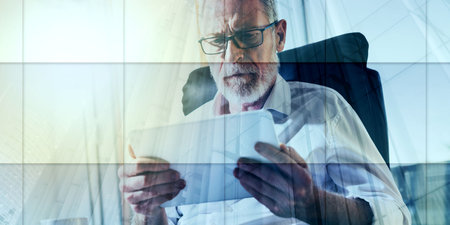 Senior businessman using a digital tablet in office, light effect, double exposure, geometric patternの写真素材