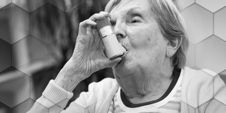 Elderly woman using an asthma inhaler, geometric patternの写真素材