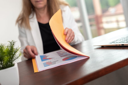 Businesswoman opening folder with paper documentsの写真素材
