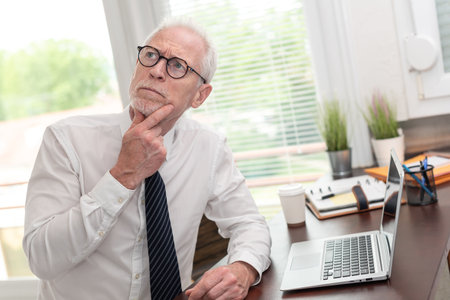 Portrait of thoughtful senior businessman at officeの写真素材
