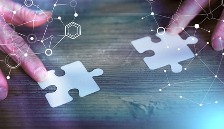 Hands joining two puzzle pieces, teamwork concept; light-effect