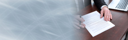 Businessman reading and checking document in office (lorem ipsum text used); panoramic bannerの写真素材