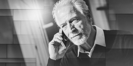 Portrait of senior modern man talking on mobile phone at home, geometric patternの写真素材