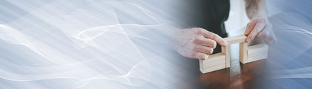 Hands building a wooden block bridge; concept of business associations; panoramic bannerの写真素材