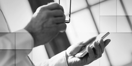 Businessman holding a mobile phone and glasses, geometric patternの写真素材