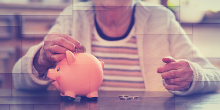 Elderly woman putting a coin in a piggy bank, geometric patternの写真素材