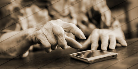 Old woman using smartphone at home, geometric patternの写真素材