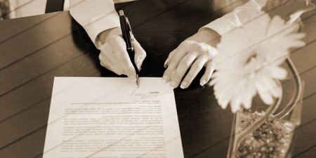 Businesswoman signing a document at office, geometric patternの写真素材
